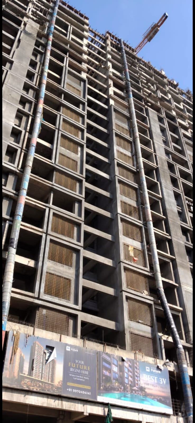 Two debris chutes running the full height of a high-rise tower under construction in Pune
