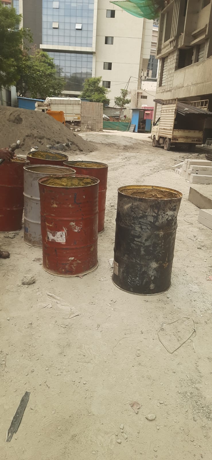 Steel drums used to build debris chute sections kept ready at a construction site in Pune